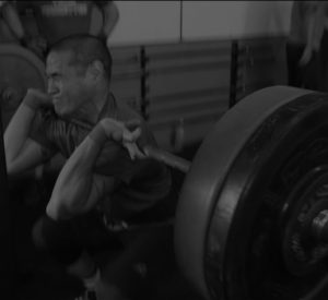 Man squats with barbell